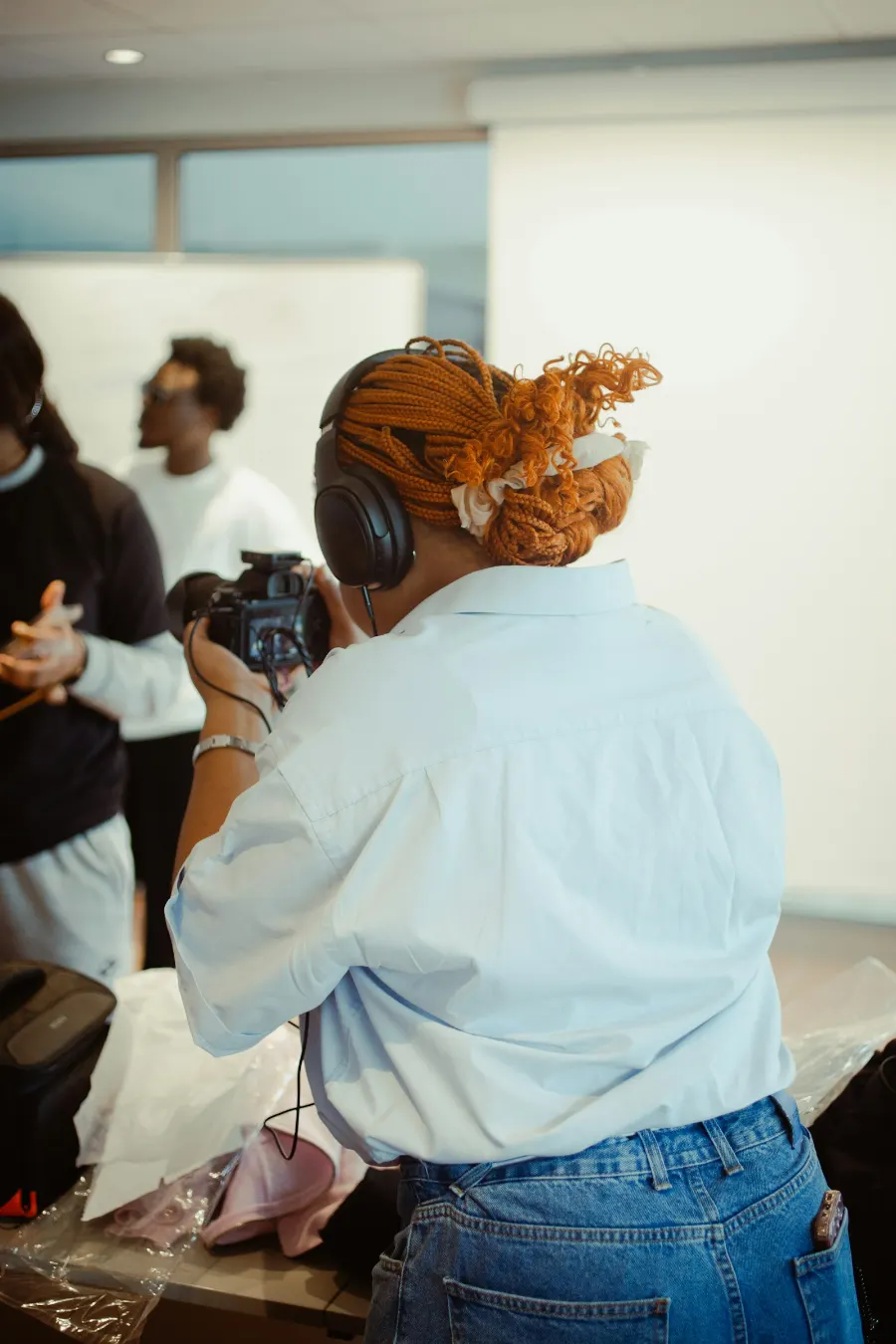 A creator wearing headphones filming a product shoot